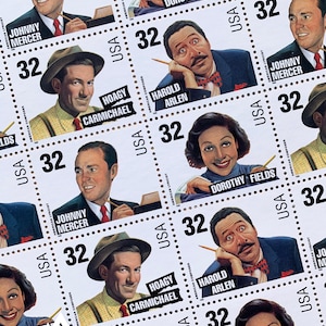 May include: A sheet of vintage USA postage stamps featuring portraits of American songwriters and lyricists. The stamps include images of Johnny Mercer, Hoagy Carmichael, Dorothy Fields, and Harold Arlen. Each stamp is marked with the number 32.