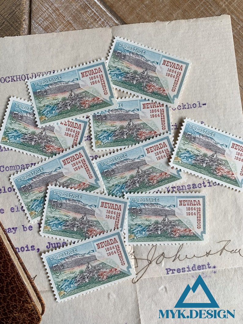 K&ouml;nnte beinhalten: Eine Sammlung von Vintage-US-Briefmarken mit dem Bundesstaat Nevada. Die Briefmarken sind blau, gr&uuml;n und rot mit dem Text "Nevada Statehood 1864 1964" auf jeder Marke.