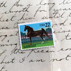 May include: A vintage USA 22-cent postage stamp featuring a brown Saddlebred horse in a field. The stamp is set against a backdrop of handwritten script on aged paper, with the text "Saddlebred" visible.