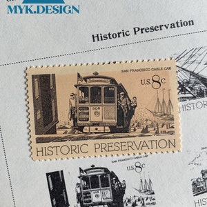 May include: A vintage United States postage stamp featuring a black and white illustration of a San Francisco cable car. The stamp is labeled "Historic Preservation" and "U.S. 8c".
