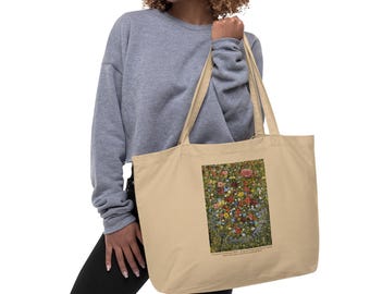May include: A beige tote bag featuring a colorful floral print. The bag is held by a person wearing a gray sweatshirt and black pants. The floral design includes red, yellow, and blue flowers.