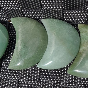 Pode incluir: Quatro pedras polidas em forma de lua crescente de cor verde. As pedras s&atilde;o lisas e t&ecirc;m uma cor verde clara.