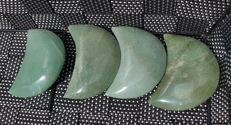 Pode incluir: Quatro pedras polidas em forma de lua crescente de cor verde. As pedras s&atilde;o lisas e t&ecirc;m uma cor verde clara.