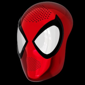 May include: A red and black plastic mask with a spider-like design. The mask has a large eye opening and a small mouth opening.