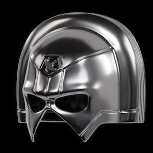 Può includere: Un casco argentato lucido con un design distintivo, caratterizzato da un mento appuntito e uno stemma con un simbolo. Il casco ha una superficie liscia e riflettente, su sfondo nero. L'estetica generale suggerisce un tema futuristico o da supereroe.