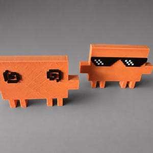 May include: Two orange, pixelated, block-shaped figures. One has black pixelated eyes, the other has black pixelated sunglasses. Both have small rectangular legs and side extensions, giving them a unique, retro aesthetic. The background is a solid gray.