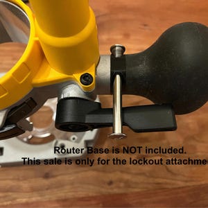 May include: A black lockout attachment for a router. The attachment has a black rubber bulb and a lever. The text "Router Base is NOT included. This sale is only for the lockout attachment." is visible in the image.