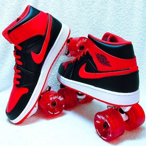 May include: A pair of black and red roller skates with red wheels. The skates have a black and red high-top design with the word "PULSE" on one of the wheels.