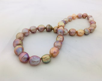 May include: Two strands of baroque pearls, one strand is a light pink color and the other is a light peach color.