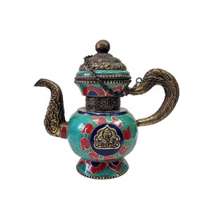 May include: A teal blue and red teapot with intricate gold detailing and a decorative bird-shaped spout. The teapot has a lid with a chain and a floral design.