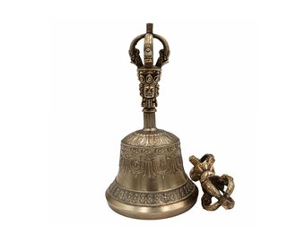 May include: A traditional Tibetan singing bowl with a hand-crafted design and a matching hand-held striker. The bowl is made of brass and has intricate carvings and inscriptions.