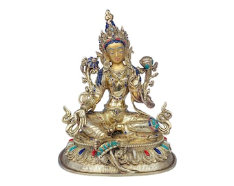 May include: A gold-colored statue of a deity sitting in a meditative pose. The statue is adorned with intricate details and colorful gemstones. The deity is wearing a crown and has a serene expression.