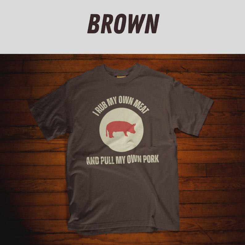 May include: A dark gray t-shirt with a white circle and a red pig illustration. The text on the shirt reads "I rub my own meat and pull my own pork."