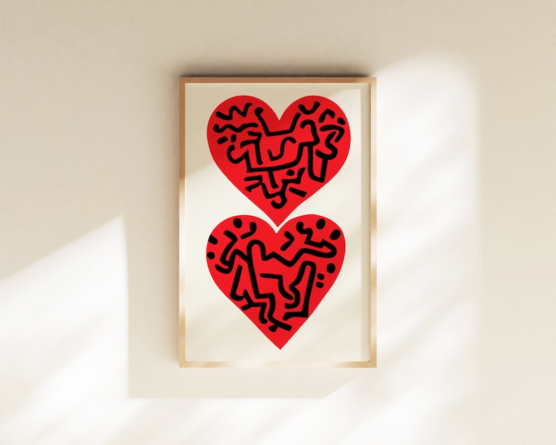 以下が含まれることがあります： 2つの赤いハートが黒色の抽象的なデザインで描かれた額装されたプリント。ハートは互いに重ねられています。