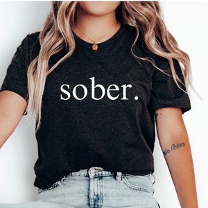 May include: A black t-shirt with the word "sober" printed in white on the front.