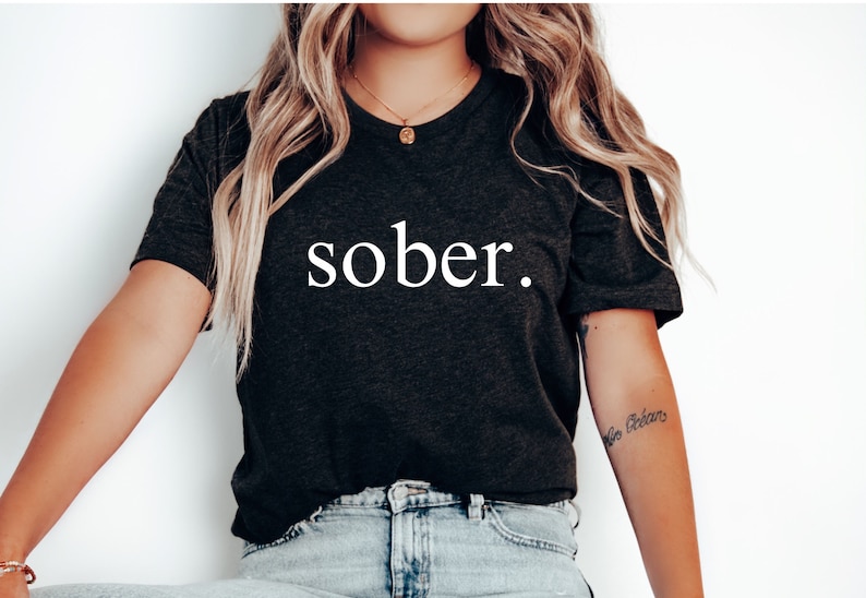May include: A black t-shirt with the word "sober" printed in white on the front.