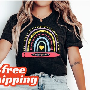 Könnte beinhalten: Ein schwarzes T-Shirt mit einem Regenbogen und einem Buntstift, auf dem "Kindergarten" steht.