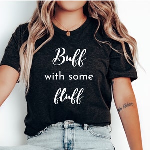 May include: A dark gray t-shirt with the text "Buff with some fluff" printed in white.