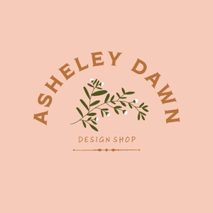 Puede incluir: Un logotipo para una tienda de dise&ntilde;o llamada "Ashley Dawn Design Shop". El logotipo presenta un arco de texto marr&oacute;n con el nombre de la tienda y una peque&ntilde;a rama de hojas verdes con flores blancas.