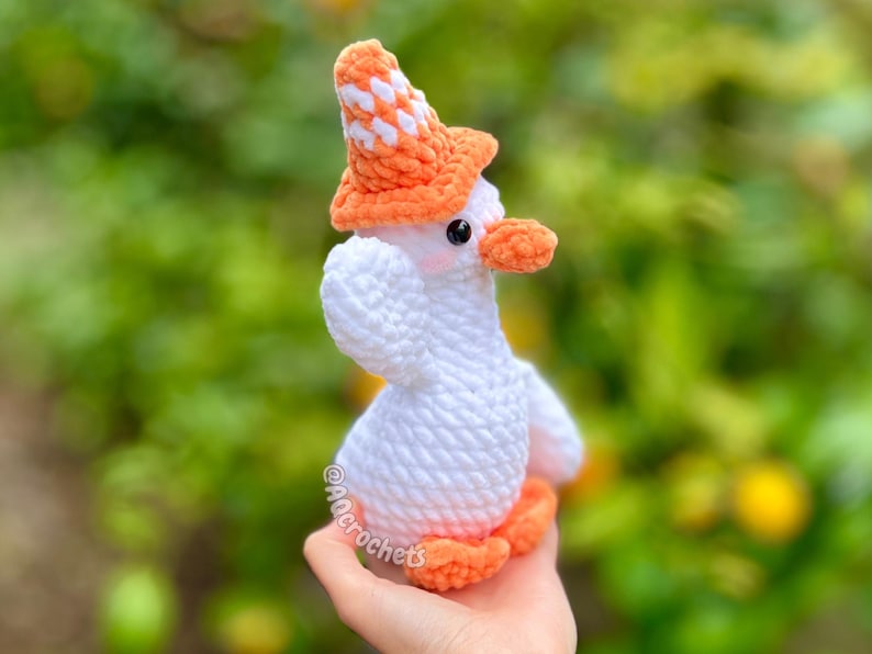 silly goose crochet pattern, low sew silly goose crochet pattern, amigurumi goose, goose wearing traffic cone hat, goose wearing frog hat, goose wearing flower hat, amigurumi bird pattern, cute crochet pattern