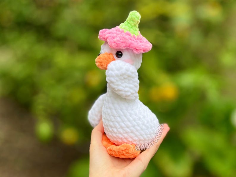 silly goose crochet pattern, low sew silly goose crochet pattern, amigurumi goose, goose wearing traffic cone hat, goose wearing frog hat, goose wearing flower hat, amigurumi bird pattern, cute crochet pattern