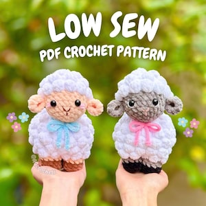 以下が含まれることがあります： 青いリボンとピンクのリボンが付いた2匹の手作りの編み物羊。羊は白いふわふわの体、茶色のひづめ、灰色のまたはタン色の顔をしています。「LOW SEW PDF CROCHET PATTERN」というテキストが羊の上に表示されています。