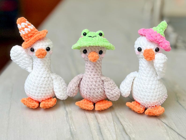 silly goose crochet pattern, low sew silly goose crochet pattern, amigurumi goose, goose wearing traffic cone hat, goose wearing frog hat, goose wearing flower hat, amigurumi bird pattern, cute crochet pattern