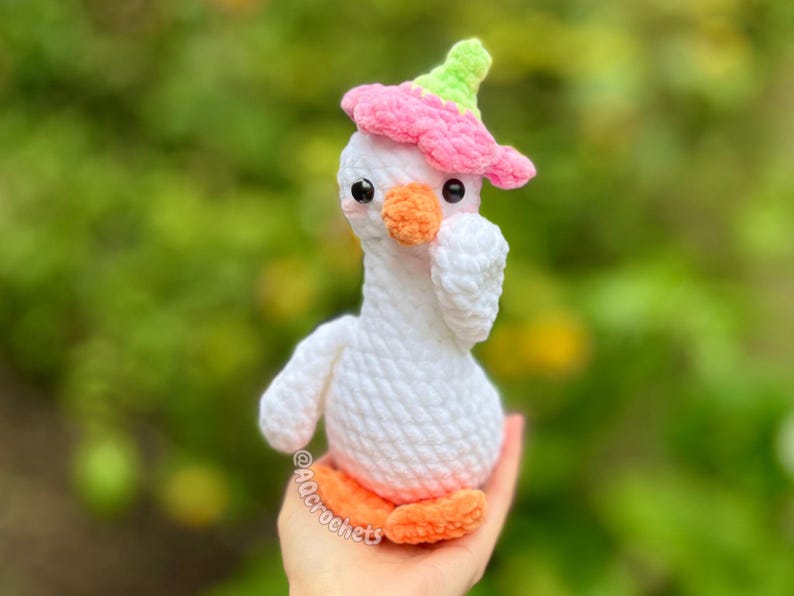 silly goose crochet pattern, low sew silly goose crochet pattern, amigurumi goose, goose wearing traffic cone hat, goose wearing frog hat, goose wearing flower hat, amigurumi bird pattern, cute crochet pattern