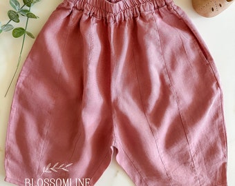 Pants with elastic waistband and front pockets. Old pink natural linen pants for baby and girl. Clothes for children. Wide mid-length pants