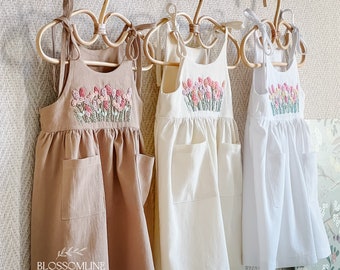 Spring-Summer dress for girls. Baby linen dress with embroidered flowers for summer. White, cream, and beige beach dress. Toddler clothing