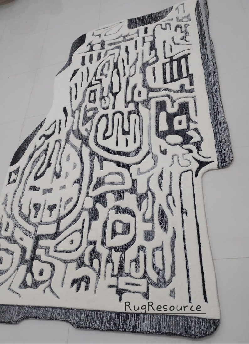 May include: Abstract black and white rug with a unique design. The rug has a textured surface and a fringed edge. The rug is made by RugResource.