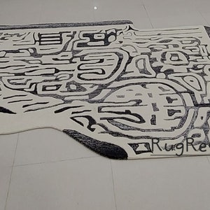 May include: Abstract black and white area rug with a unique, modern design. The rug has a slightly irregular shape and features a black border. The text "RugResource" is visible in the lower right corner.