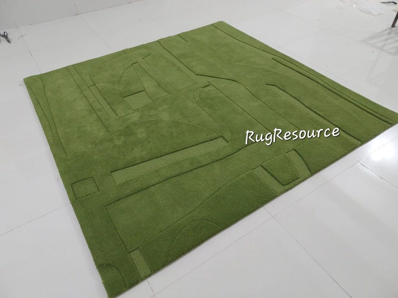 May include: A green shag rug with a geometric pattern. The rug has a raised design, creating a textured surface. The rug is made of soft, plush fibers.