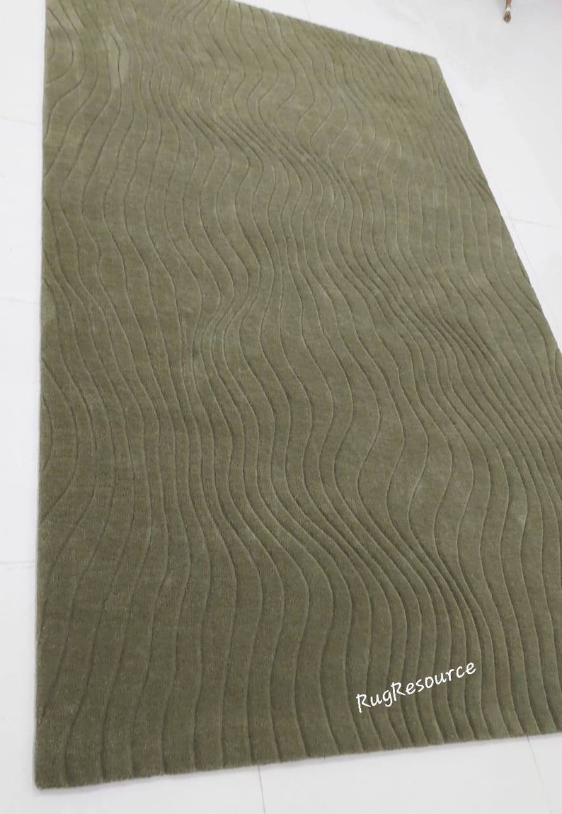 May include: A green shag rug with a wavy, textured pattern. The rug is made of soft, plush fibers and has a modern, contemporary design.