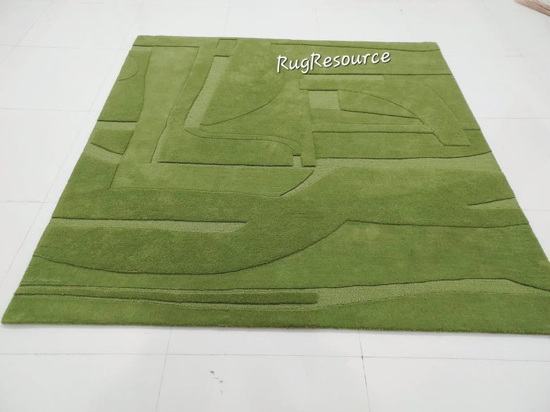 May include: A green area rug with a modern abstract design. The rug has a raised texture and a subtle sheen.