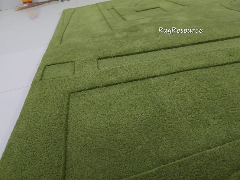 May include: A green shag rug with a geometric pattern. The rug has a raised design that creates a textured surface.