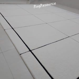 Pu&ograve; includere: Tappeto rettangolare bianco con un design geometrico. Il tappeto presenta un motivo a griglia con linee scure. Il testo "RugResource" si trova nell'angolo in alto a destra. Il tappeto &egrave; su una superficie bianca.