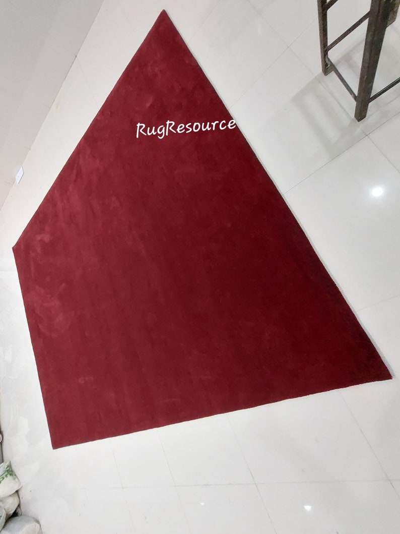 May include: A large, triangular, burgundy-colored rug with the text "RugResource" printed in white in the center.