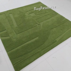 May include: A green shag rug with a geometric pattern. The rug has a raised texture and is made of soft, plush fibers.