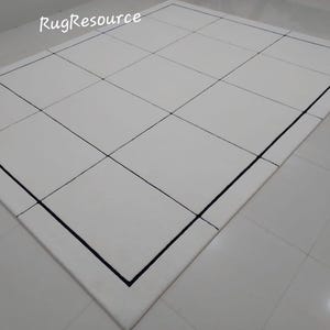 Pu&ograve; includere: Un tappeto rettangolare bianco con un motivo a griglia creato da linee nere. Il tappeto ha un bordo nero ed &egrave; posizionato su un pavimento piastrellato bianco. Il testo "RugResource" &egrave; visibile nell'angolo in alto a sinistra.