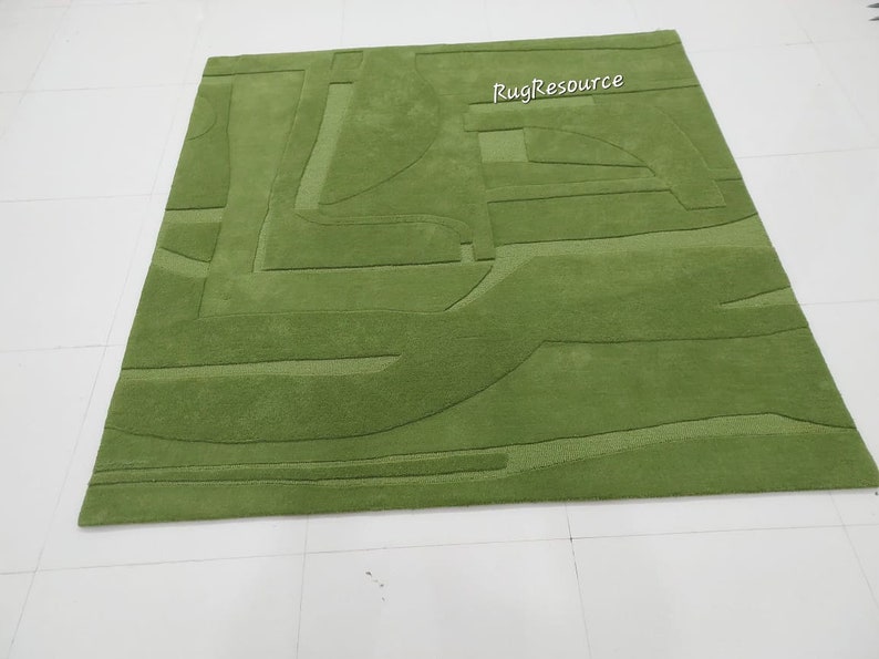 May include: A green area rug with a modern abstract design. The rug has a raised texture and is made of a soft, plush material.