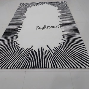 May include: Black and white rug with a large oval shape in the center. The oval is surrounded by black lines radiating outward. The text "RugResource" is visible in the center of the oval.