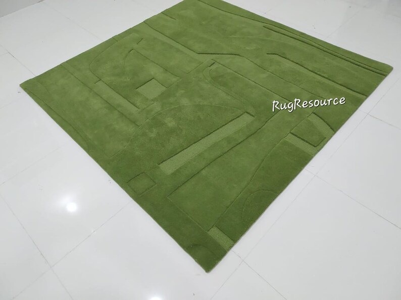 May include: A green, abstract patterned rug with a raised texture. The rug is made of a soft, plush material. RugResource is printed in white on the rug.