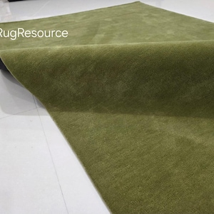 May include: A folded, olive green rug with a soft, textured surface. The rug is displayed on a white surface, with the text "RugResource" visible in the upper left corner. The rug's color is consistent throughout.