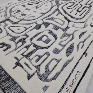 May include: A white rug with a black and gray abstract design. The design features a variety of shapes and lines, creating a modern and geometric look. The rug has a black border and the text "RugResource" is printed in the bottom right corner.