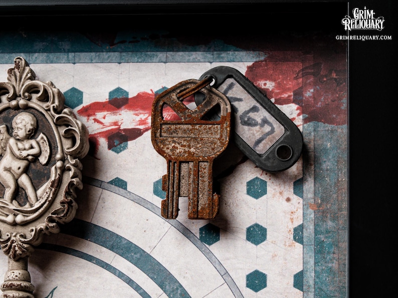 May include: A close-up of a vintage-style key with a rusty appearance, paired with a black tag labeled "K67". The key rests on a patterned background with a clock design and red accents. A decorative frame with an angel is visible.