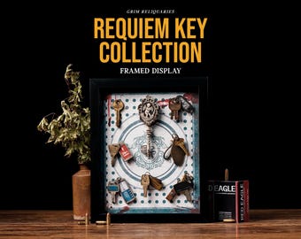 May include: A framed display featuring a collection of antique keys. The keys are arranged on a patterned background within a black frame. The text "REQUIEM KEY COLLECTION FRAMED DISPLAY" is at the top. A vase with dried plants and a box of bullets are also in the image.
