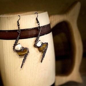 May include: A pair of handmade earrings with copper wire wrapped around white and brown stones.