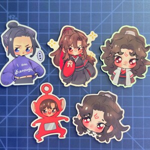 May include: Five colorful cartoon character stickers. The stickers feature characters with brown hair, black eyes, and red cheeks. One sticker has a character wearing a blue sweater with the text "I am enough". Another sticker has a character wearing a red and black outfit. The remaining stickers feature characters with different hairstyles and expressions.