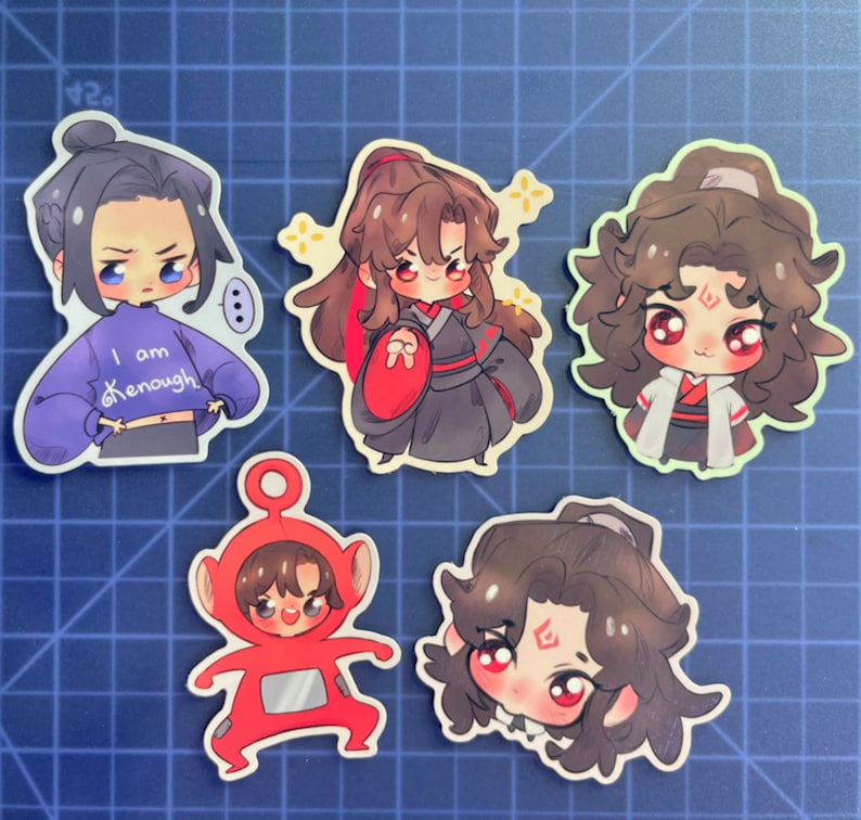 May include: Five colorful cartoon character stickers. The stickers feature characters with brown hair, black eyes, and red cheeks. One sticker has a character wearing a blue sweater with the text "I am enough". Another sticker has a character wearing a red and black outfit. The remaining stickers feature characters with different hairstyles and expressions.